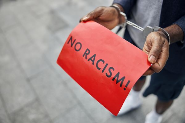 Homem negro protestando contra racismo e sendo preso